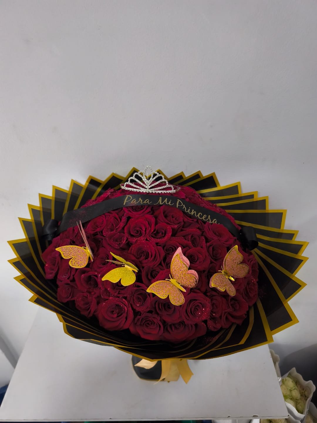 ramo de rosas rojas con mariposas, cinta y corona